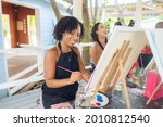 Small photo of A group of Young individuals enjoying paint n sip activities outdoor. A beginners class for painting. Nassau, Bahamas - May 29th, 2021