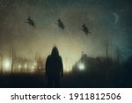 Small photo of A man watching three witches on broomsticks flying across the sky in a city on a spooky winters night. With a grunge, abstract edit.