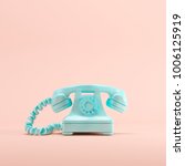 Blue vintage telephone on pink...
