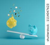 Small photo of Blue and Yellow piggys bank playing with gold coin on seesaw on blue background. minimal idea funny concept.