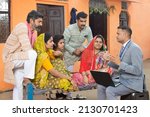 Small photo of Rural indian family meeting with bank manager or financial advisor. Male agent with laptop explaining the scheme.