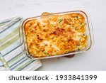 Top view of cauliflower, broccoli and cheese casserole in rectangular shape glass baking dish.