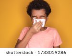 Little afro child boy blow his nose. Sick child with napkin . Allergic kid, flu season. Kid with cold rhinitis, get cold snot nose. virus and infection