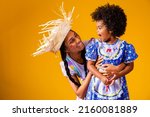 Small photo of young mother and little daughter dressed in festa junina outfit for the june party.