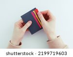 Credit bank cards in a gray business card holder in the hands of a caucasian woman. White background. View from above.