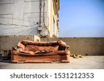 Sad and rustic lonely place with a shabby discarded empty couch that is torn and dirty with tangled wires on the back wall with a lot of empty space for copy