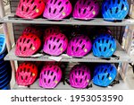 Various colors bike helmets on sport store display. Bicycle safety accesories shopping