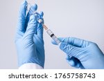 Small photo of Doctor, nurse, scientist, researcher hand in blue gloves holding flu, measles, coronavirus, covid-19 vaccine disease preparing for human clinical trials vaccination shot, medicine and drug concept.