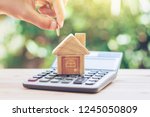 House is placed on the calculator. hand that is coin down the house. planning savings money of coins to buy a home concept for property, mortgage and real estate investment.to buy a house.