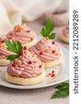 Small photo of Beautiful Italian canapes with mortadella and ricotta cream mousse or Spuma di mortadella on a small tigelle bread, decorated with red pepper, toasted almond and parsley. Appetizer, snacks. Festive.