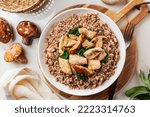 Boiled buckwheat with mushrooms porcini, turkey meat, spinach. Dinner table top view, healthy food concept.