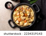 Small photo of Top view of Blanquette de poulet, is a French chicken stew with carrots, mushrooms, onion. Simmered in a white stock and served in a sauce enriched with cream, herbs.