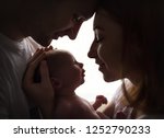 Happy family with newborn baby by the window