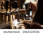 closeup of a bartender pouring a dark stout beer in tap with subject and focus on the right