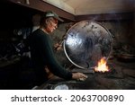Small photo of Ankara, Turkey - October 2021: The tinsmith who repaired the old coppers, the man who polished the copper in the smoke, the tinsmith profession began to be forgotten.