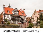 Small photo of A view of traditional polish house at the Mill Island in Gdansk's Old Town in Poland. St. Cathrine's Church is in the background.