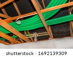 Home energy recovery ventilation, visible system of green flexible pipes for air transport, spread over the roof trusses.