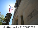 US Department of Justice building under the national flag of the United States on a sunny day, Washington DC, United States