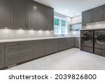 large laundry room with long counter grey cabinets and under cabinet lighting