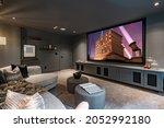 home theatre with low lighting grey furnishings large projection screen and popcorn
