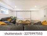 recreation party room with bar stairs with glass rails downstairs basement interior room with movie screen large grey sofa bohemian style