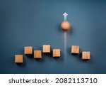 Small photo of Leadership, business success, unique, difference, challenge, and motivation concepts. Wooden sphere rolling faster leading with rising arrow and following with wood cube blocks on blue background.