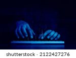 Cyberattack and internet crime, hacking and malware concepts. Digital binary code data numbers and secure lock icons on hacker' hands working with keyboard computer on dark blue tone background.