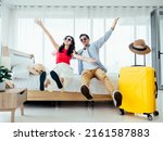Small photo of Ready to travel, happy holiday, check-in. Summer vacation concept. Asian couple raising hands with joy, man and woman wear sunglasses smile with happy on white bed with yellow suitcases on a trip.