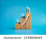 Small photo of Shining rise up arrow on wooden cube blocks with percentage icon on coin stacked, bar graph chart steps, investment, profit, benefit, income, banking, business growth, economic improvement concepts.