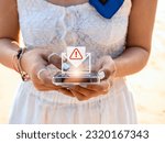 SMS spam and fake text message phishing concept. System hacked warning alert, email hack, scam malware spreading virus on message alert virtual on mobile smart phone screen in woman's hands.