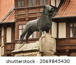 Small photo of Braunschweiger Lowe, Brunswick Lion statue located in the old town of Braunschweig, Lower Saxony, Germany. Landmark, a symbol of the city. Sculpture isolated in front of historic half-timbered houses.