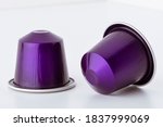 Two coffee capsules close-up on white background