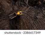 Small photo of Aerial view directly above an industrial dumper truck or earth mover vehicle with muddy soil and tyre tracks in the construction industry on a brownfield site with copy space