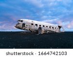 Famous abandoned plane wreck on Solheimasandur in Iceland. Old wreckage of airplane crashed in 1973 on black sand beach as tourist attraction. Douglas Dakota DC3, US navy. Traffic accidents concept.
