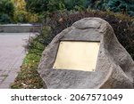 Small photo of Blank plaque on the stone. Bronze memorial plaque in the park. Empty sign board on the wall.