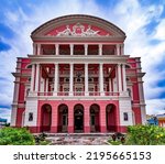 The unique richness of the details of the renaissance facade of the Amazonas theater in the city of Manaus with the partly cloudy sky above.