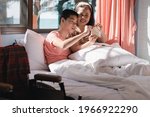 Small photo of Disabled child on the bed in his home with parent with sunrise in morning,Mother taught to save money for future,Lifestyle of disability kid, Living skills learning to help oneself,Homeschool concept.