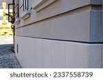 Small photo of newly renovated old house elevation in diminishing perspective. stone footing and window sill. grooved stucco facade finish. residential architecture. soft blurred street background. open wood window