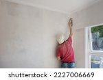 Small photo of Man plastering and GIB stopping in a residential house. Home renovation project.
