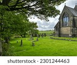 Small photo of View of, St. Aidan's Church, with old trees, gravestones, and distant fields, on a cloudy day in, Buttershaw, Bradford, UK