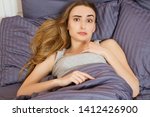 Small photo of Woman suffering from insomnia or indisposition in bed at home and looking at camera
