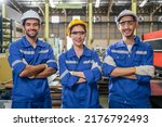 Small photo of Portrait Group of male and female industrial worker working in factory. Attractive manufactory industry engineer people wear helmet and look at camera at manufacturing plant warehouse with happiness.