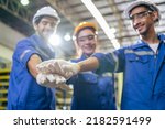 Small photo of Group of young industrial people worker work in factory with happiness. Attractive manufactory engineer man and woman stack hands for motivate and work unity teamwork at manufacturing plant warehouse.