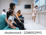 Small photo of Asian family patient wait on line queue to receive medicine in hospital. Attractive mother and daughter sit on chairs, waiting the pharmacy counter to provides services to patients in medical center.