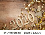 New Year celebration and festive background with golden numbers 2020, confetti stars and Christmas decorations top view.
