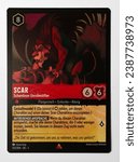 Small photo of Hamburg, Germany - 10312023: macro photo of the German Ravensburger trading card Scar Shameless Firebrand from the Disney lorcana The first chapter set on white paper background.
