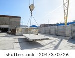 Small photo of Moving a pdn road slab by a crane across the warehouse of a reinforced concrete plant