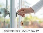 Small photo of Landlord key for unlocking house is plugged into the door. Second hand house for rent and sale. keychain is blowing in the wind. mortgage for new home, buy, sell, renovate, investment, owner, estate