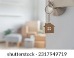 Small photo of Moving house, relocation. The key was inserted into the door of the new house, inside the room was a cardboard box containing personal belongings and furniture. move in the apartment or condominium