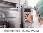 Small photo of quality supervisor or food or beverages technician change parameter and condition control food or beverages before send product to the customer. Production leader recheck machine and productivity.